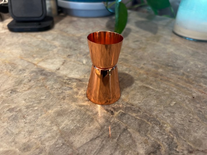A copper jigger on a countertop.