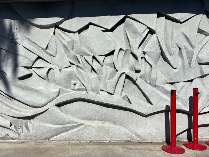 An image of the concrete murals at Dodger Stadium with a pair of tensabarrier posts at right.