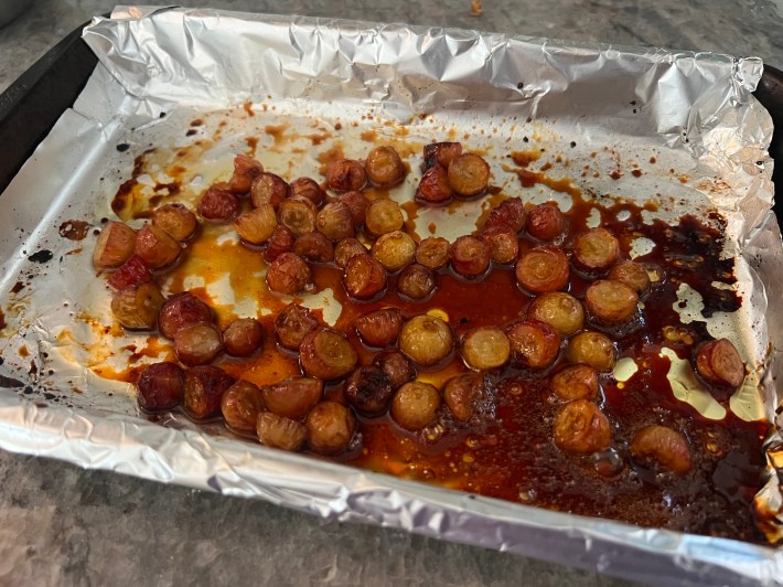 Roasted grapes in a foil-lined baking pan
