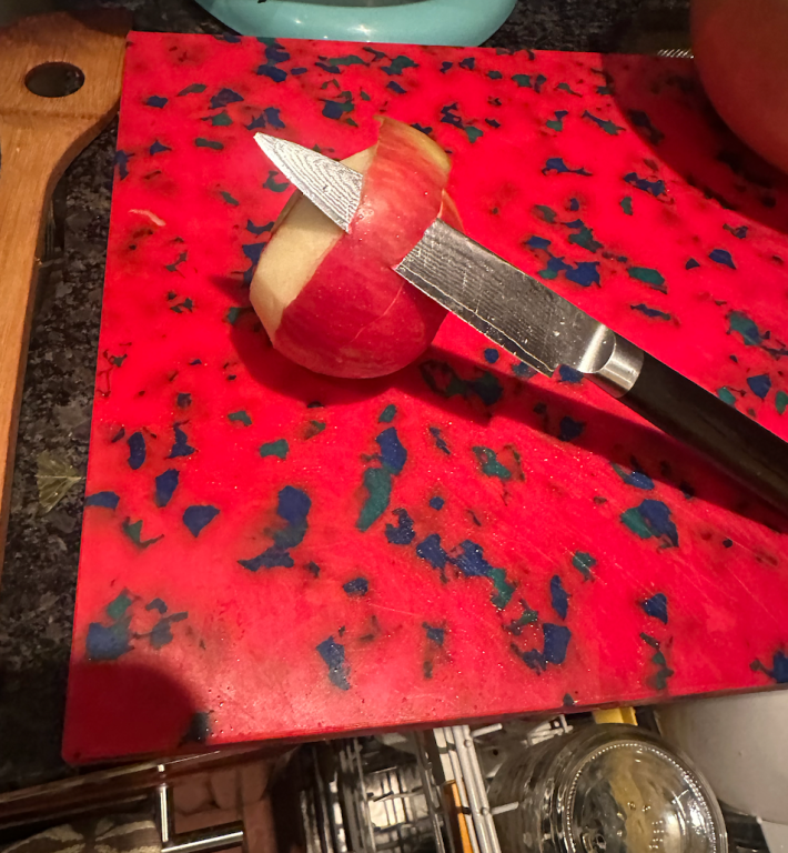 Knife peeling an apple