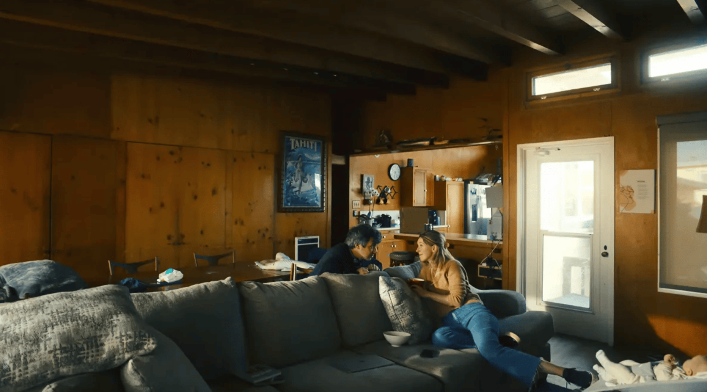 nathan fielder and elizabeth holmes sit on either side of a couch, staring into each other's eyes