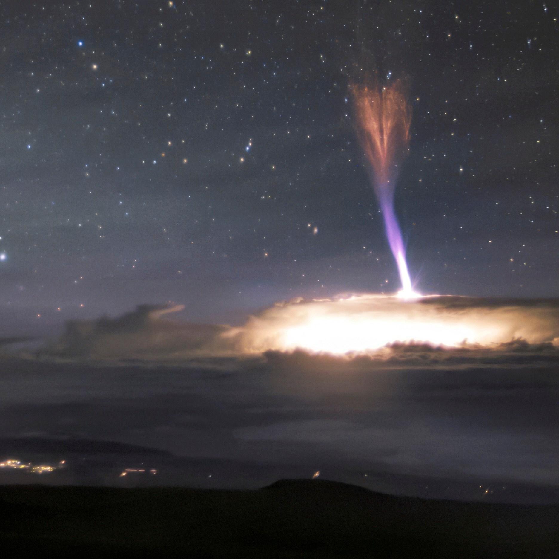 The telescopes at Maunakea sit calmly beneath a sky filled with extraordinary light. Amongst these telescopes is Gemini North, the northern member of the international Gemini Observatory, a Program of NSF NOIRLab. Gemini North sits at an altitude of around 4200 meters (13,800 feet). Not only does this altitude facilitate world-class astronomical observations, but Gemini North’s nighttime Cloudcams were able to capture the extraordinary light phenomena seen on the right side of the image. The column of blue and red lights surrounded by a bright blaze of white light appears so otherworldly that it looks like it must be a special effect. This breathtaking image, however, is entirely real. It features the lightning phenomena named a red sprite. Red sprites are distinctive because of their color, and also the direction in which they strike. The red and blue lights are shooting down from 50-90 kilometers toward the top of the cloud deck. It is extremely rare to capture these phenomena on camera and even more so from this unique perspective. This image was taken on 24 July 2017.